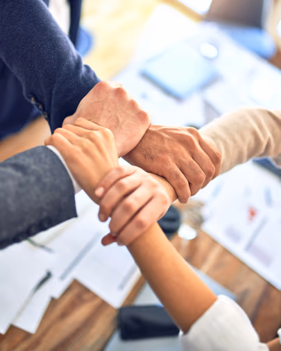 Manos de un equipo de trabajo unidas sobre una mesa